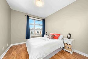 Calgary apartment for rent - A bedroom with a bed, nightstand, and window.