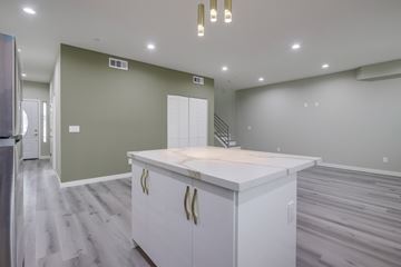 Santa Ana apartment for rent - A kitchen with a white countertop and cabinets with gold handles.