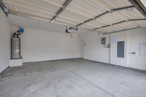 Santa Ana apartment for rent - A spacious garage with a concrete floor and white walls.