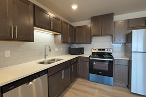 Fargo apartment for rent - A modern kitchen with dark brown cabinets and stainless steel appliances.