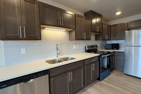 Fargo apartment for rent - A kitchen with brown cabinets and a white counter.