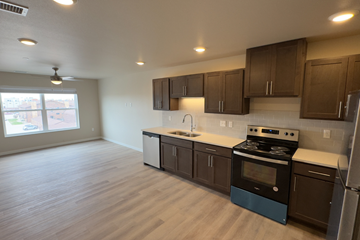 Fargo apartment for rent - A kitchen with brown cabinets and a blue stove top oven.