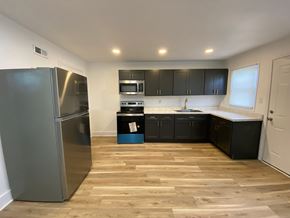 Louisville house for rent - A kitchen with a refrigerator, microwave, oven, and cabinets.
