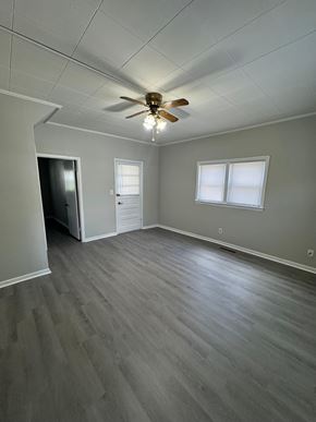 Findlay apartment for rent - A room with a ceiling fan and light fixture, a door, and a window with blinds.