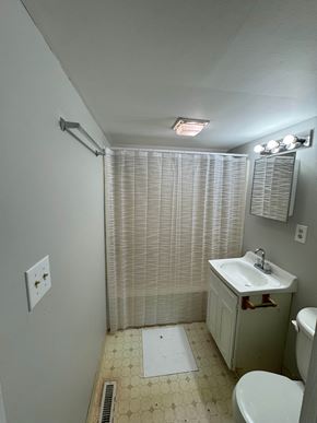 Findlay apartment for rent - A bathroom with a toilet, sink, and shower curtain.