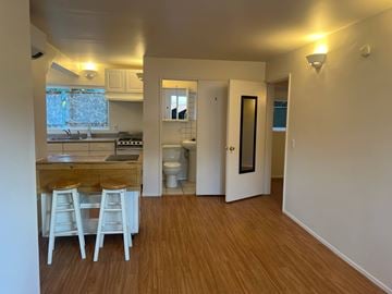 Santa Barbara apartment for rent - A kitchen with white chairs and a wooden counter.