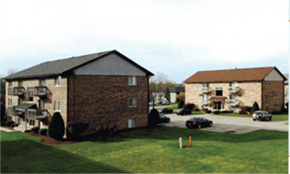 Westmont apartment for rent - A building with a black roof and a parking lot in front.