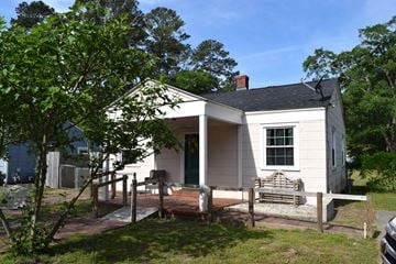 Florence house for rent - A small white house with a porch and a tree in front.