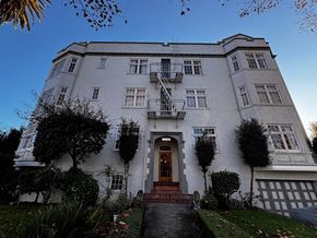 Alameda apartment for rent - A large white building with a red door and a balcony.