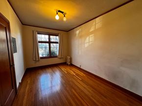 Alameda apartment for rent - A room with wooden floors and a window with white curtains.