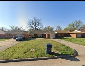Oklahoma City house for rent - A residential area with houses and a parked car.