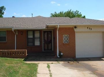 Oklahoma City house for rent - A red brick house with a white garage door and a number 32 on the front.
