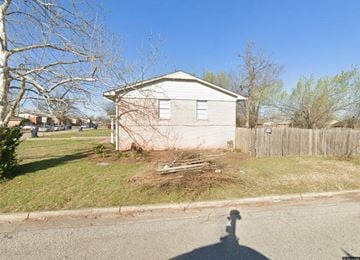 Oklahoma City house for rent - A small house with a fence and a bare tree in front.