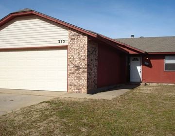 Oklahoma City house for rent - A red house with a white garage door and number 213 on the side.