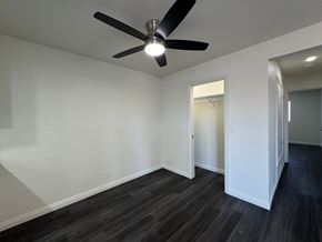 Anaheim apartment for rent - A room with a ceiling fan and a doorway leading to another room.