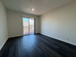Anaheim apartment for rent - A room with a sliding glass door leading to a balcony.