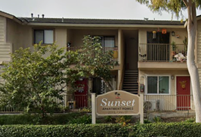 Anaheim apartment for rent - The image shows a building with a sign that reads "Sunset Apartment Homes.".