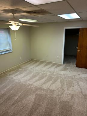 Erlanger house for rent - A carpeted room with a ceiling fan and a door.