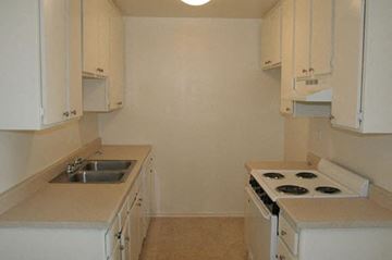 Van Nuys apartment for rent - A kitchen with white cabinets and a stove top oven.