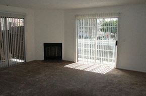 Van Nuys apartment for rent - A room with a fireplace and a window with bars.