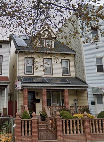 Brooklyn apartment for rent - A house with a fence and a tree in front of it.