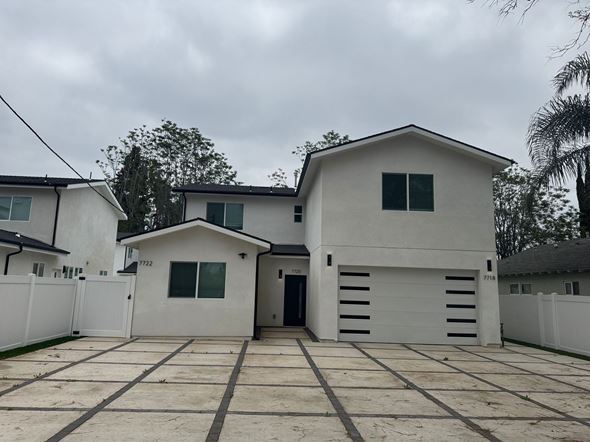 Canoga Park apartment for rent - A white house with a black door and windows is surrounded by a white fence.