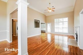 Clarksville house for rent - A spacious room with wooden floors and a ceiling fan.