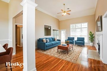 Clarksville house for rent - A living room with a blue couch and a ceiling fan.