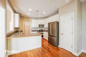 Clarksville house for rent - A kitchen with wooden floors and white cabinets.