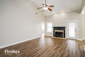 Clarksville house for rent - A spacious room with wood flooring and a fireplace.