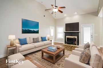 Clarksville house for rent - A living room with a fireplace and a painting on the wall.