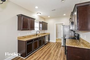Clarksville house for rent - A kitchen with wooden cabinets and a granite countertop.
