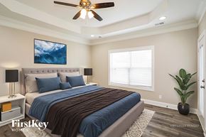 Clarksville house for rent - A bedroom with a bed, a ceiling fan, and a painting on the wall.