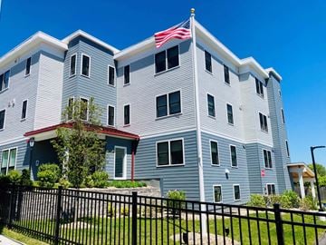 Quincy apartment for rent - A large building with a flag on top.
