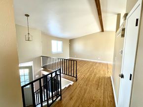 Aurora apartment for rent - A room with wooden floors and a balcony with black railings.