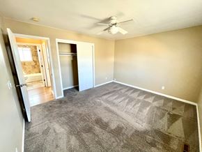 Aurora apartment for rent - A room with a grey carpet and a ceiling fan.