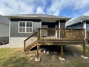 Little Rock house for rent - A house with a grey and white exterior and a wooden deck.