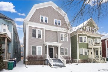 Buffalo apartment for rent - A house with a grey front and a white door is in the snow.