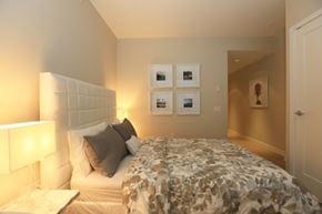 Vancouver apartment for rent - A bedroom with a bed, nightstand, and pictures on the wall.
