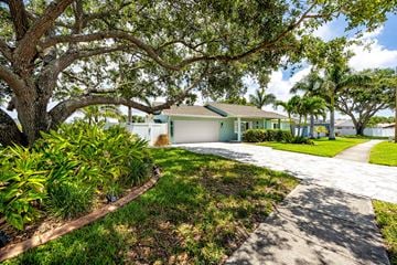 Largo house for rent - A house with a driveway and a large tree in front.