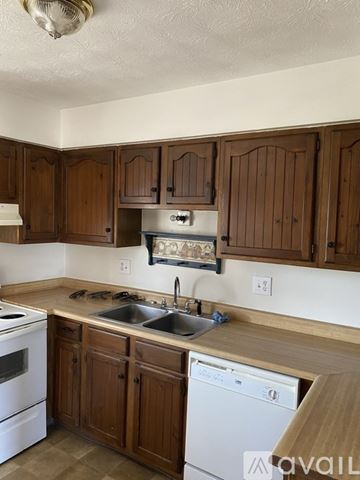 Williamsburg townhouse for rent - A kitchen with wooden cabinets and a white dishwasher.