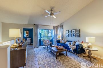 Tampa apartment for rent - A living room with a blue couch and a coffee table.
