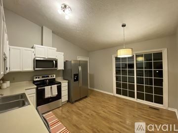 Knoxville house for rent - A kitchen with white cabinets and a stainless steel refrigerator.