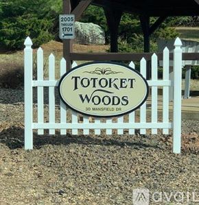 Northford apartment for rent - A sign for Totoket Woods is in front of a white picket fence.