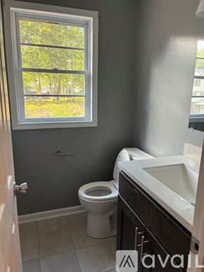 Northford apartment for rent - A bathroom with a toilet, sink, and a window.