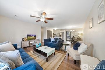 Maryville apartment for rent - A living room with a white ceiling fan and a television on a wooden cabinet.