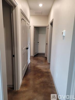 Bullard house for rent - A long hallway with white walls and brown floors.