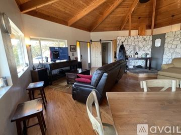 Medford house for rent - A living room with a black couch and wooden floors.