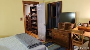 Rosendale house for rent - A bedroom with a bed, a dresser with a television on top, and a chair.