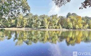 Rosendale house for rent - A serene lake surrounded by trees reflecting the sky and foliage.